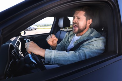 Photo of Man singing in car, view from outside