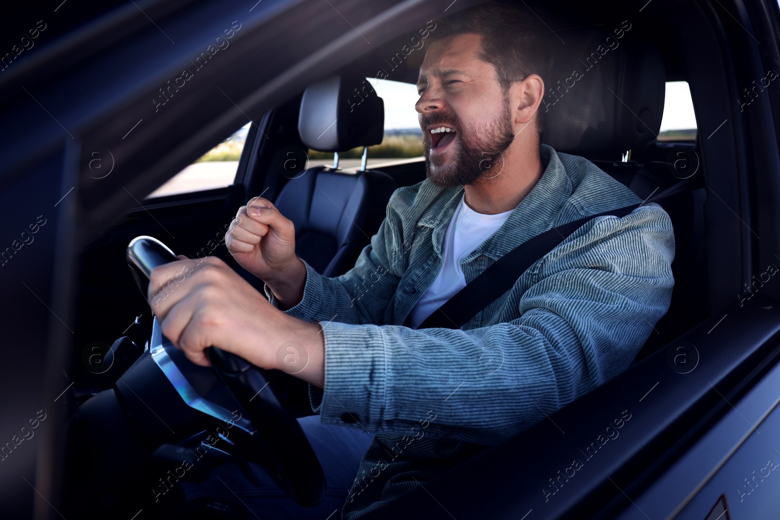 Photo of Man singing in car, view from outside