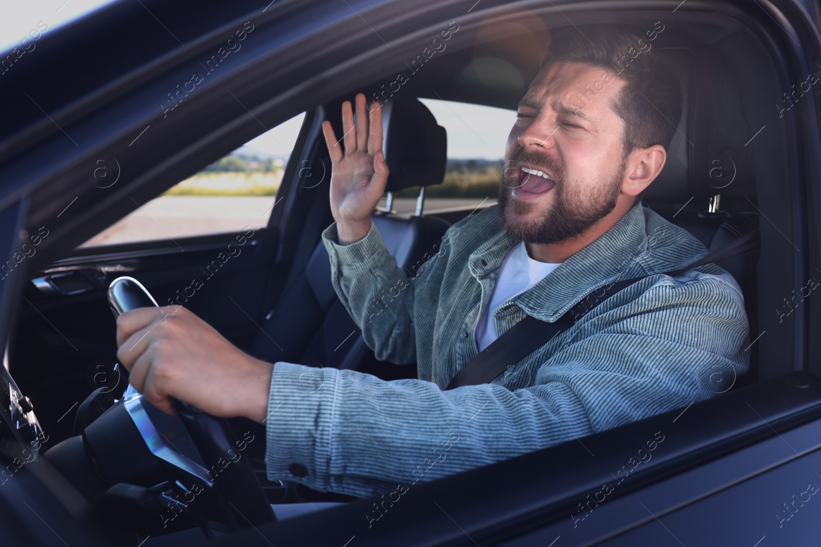 Photo of Man singing in car, view from outside