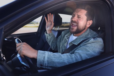 Photo of Man singing in car, view from outside