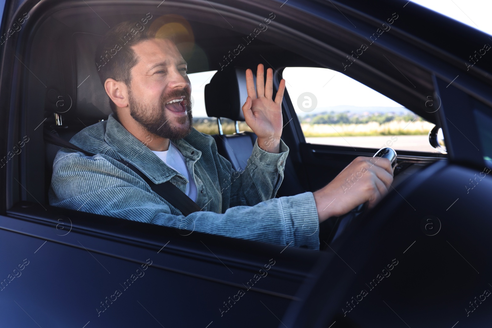 Photo of Man singing in car, view from outside