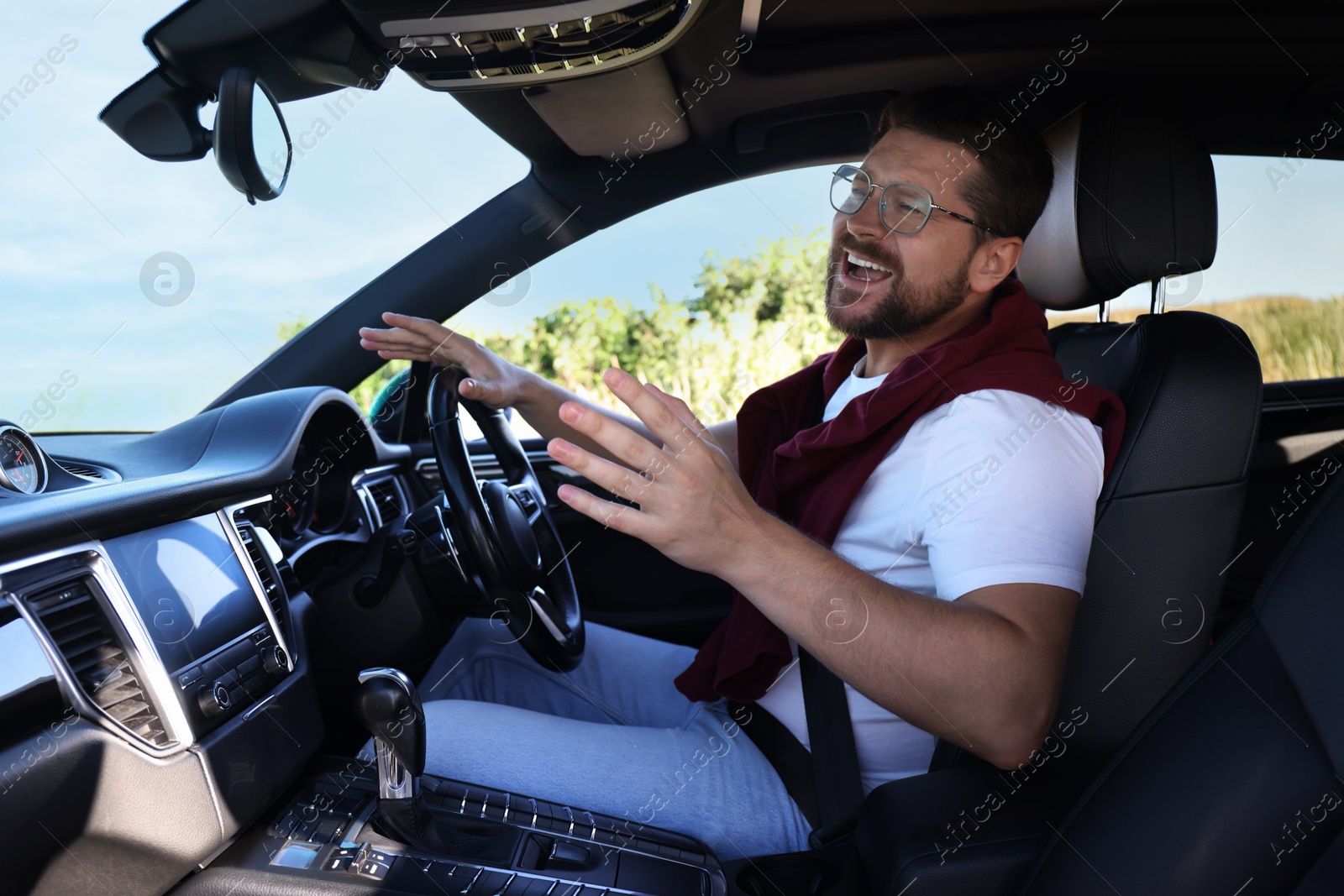 Photo of Man singing in car, view from inside