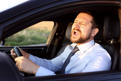 Man singing in car, view from outside