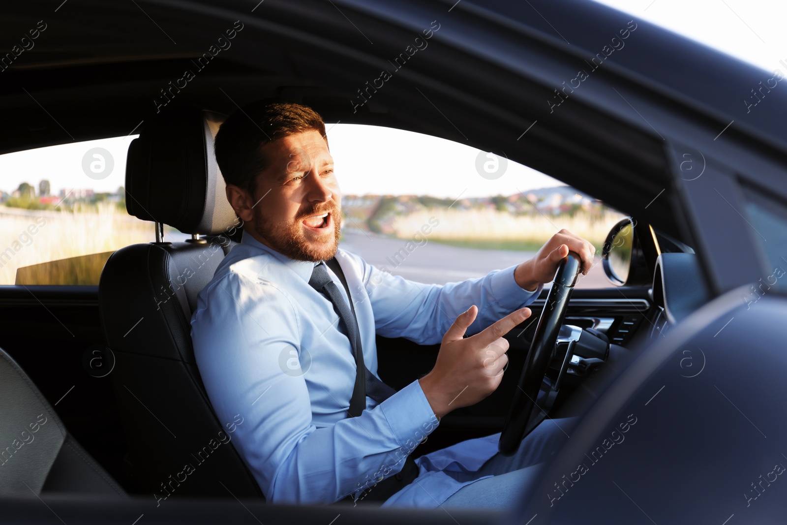 Photo of Man singing in car, view from outside