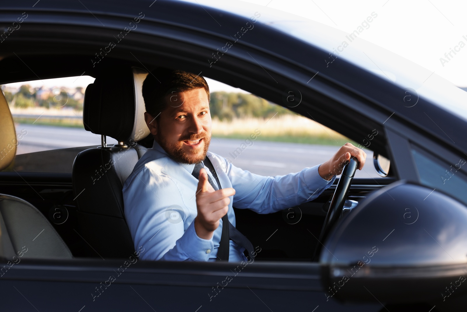 Photo of Man singing in car, view from outside