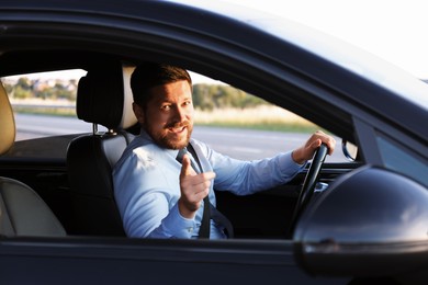 Photo of Man singing in car, view from outside