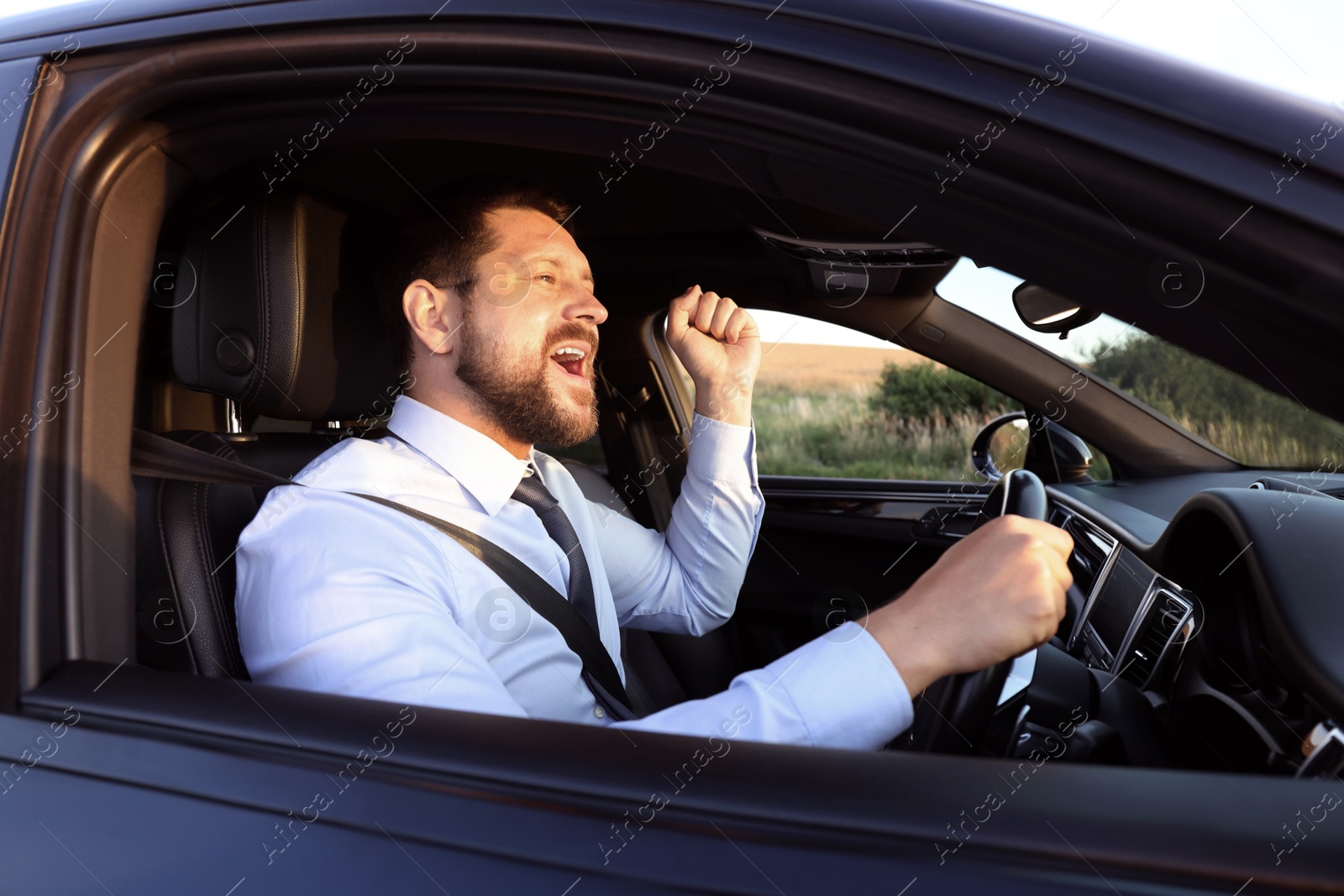 Photo of Man singing in car, view from outside