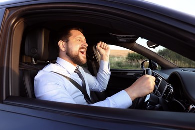 Man singing in car, view from outside