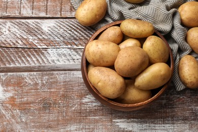 Photo of Many fresh potatoes on wooden rustic table, top view. Space for text