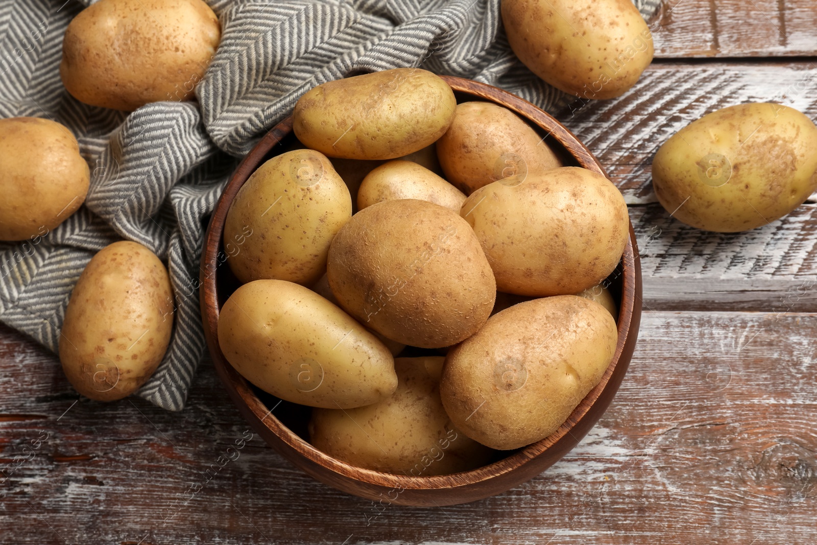 Photo of Many fresh potatoes on wooden rustic table, flat lay