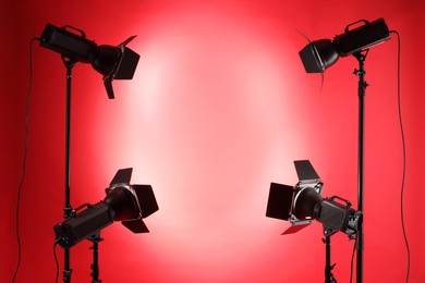 Photo of Red photo background and professional lighting equipment in studio