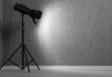 Photo of Grey photo background and professional lighting equipment in studio, space for text