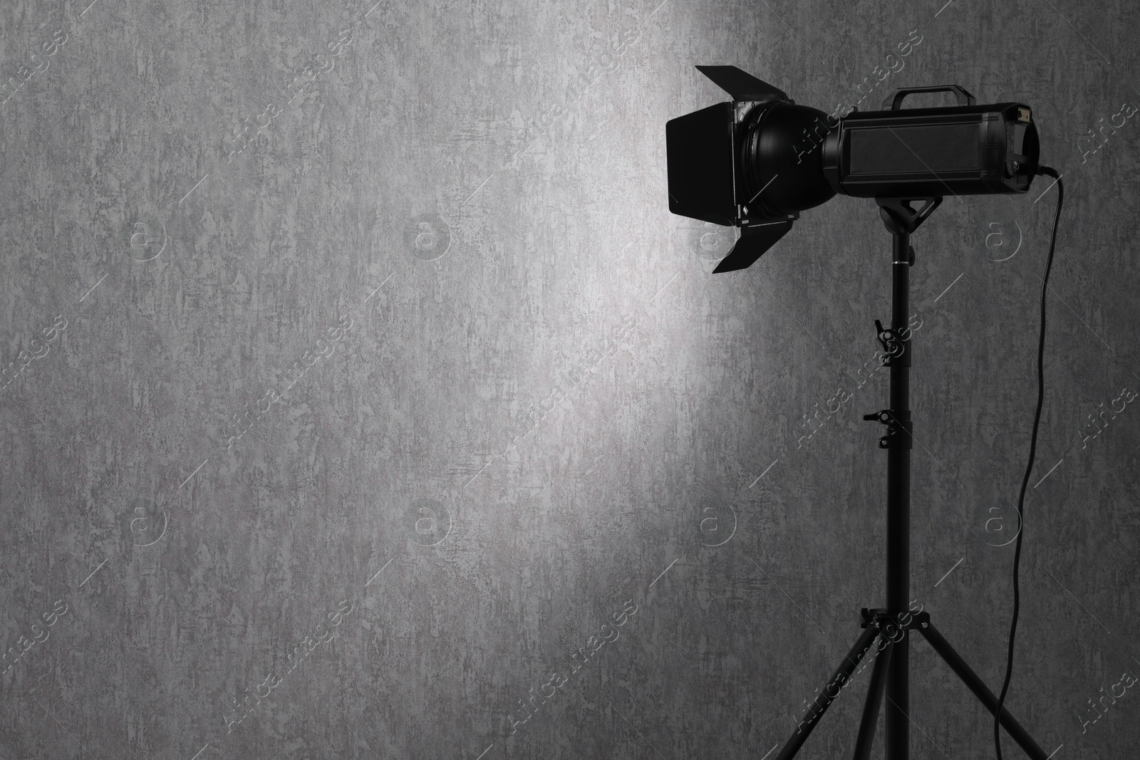 Photo of Grey photo background and professional lighting equipment in studio, space for text