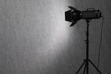 Grey photo background and professional lighting equipment in studio, space for text