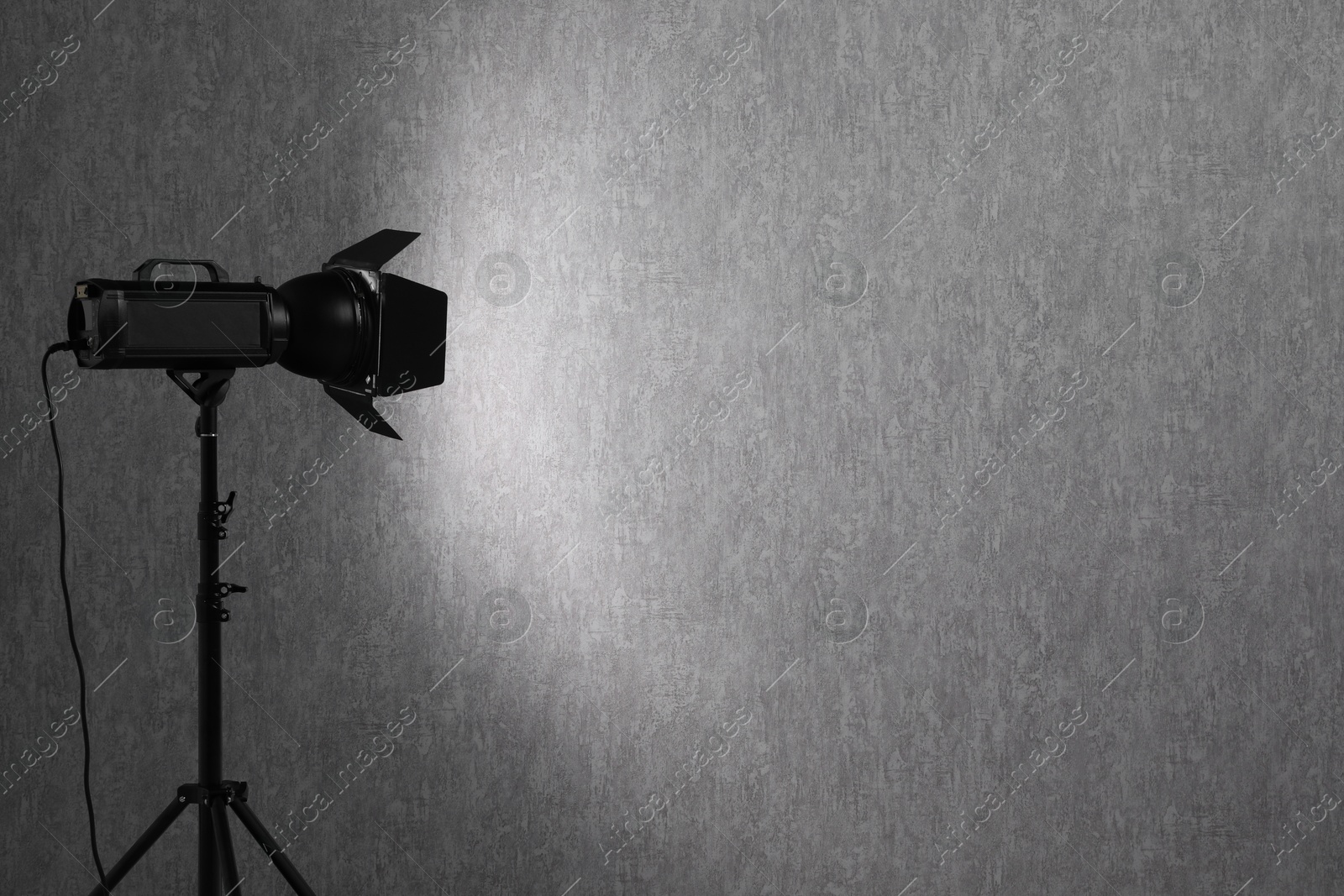 Photo of Grey photo background and professional lighting equipment in studio, space for text