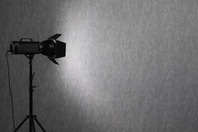 Grey photo background and professional lighting equipment in studio, space for text