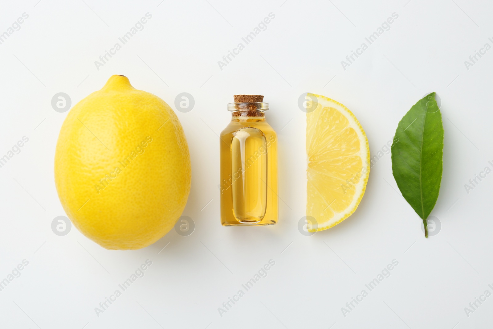 Photo of Bottle of essential oil, lemon and green leaf on white background, flat lay