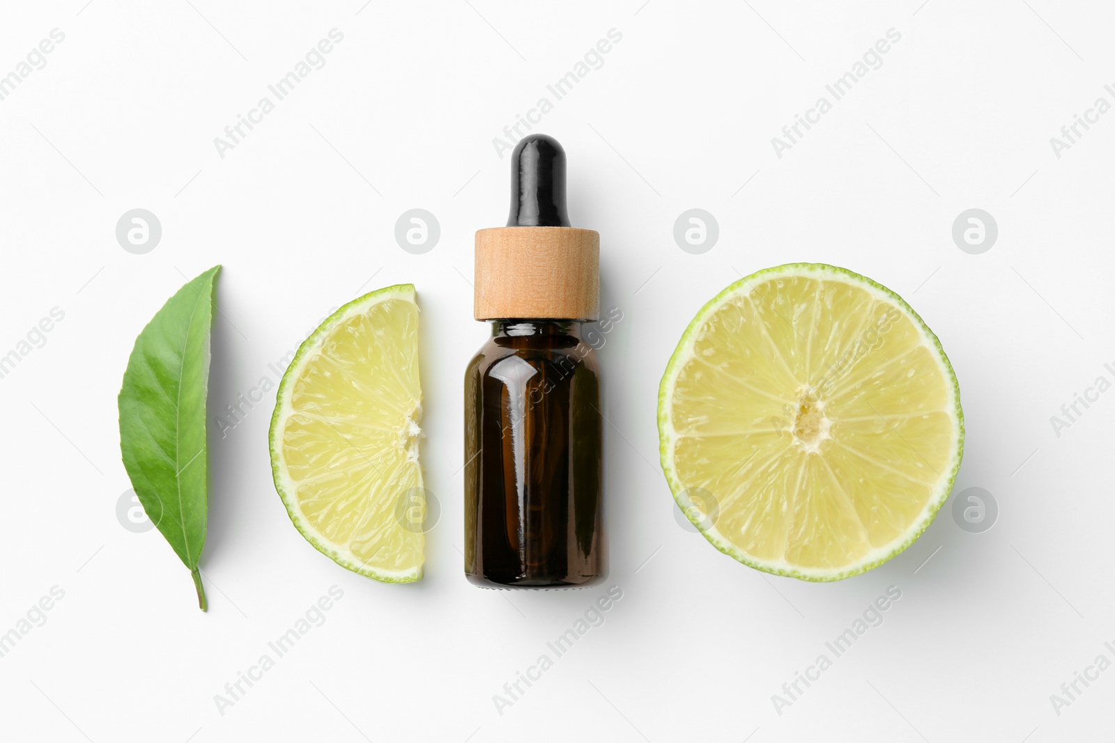 Photo of Bottle of essential oil, lime and green leaf on white background, flat lay