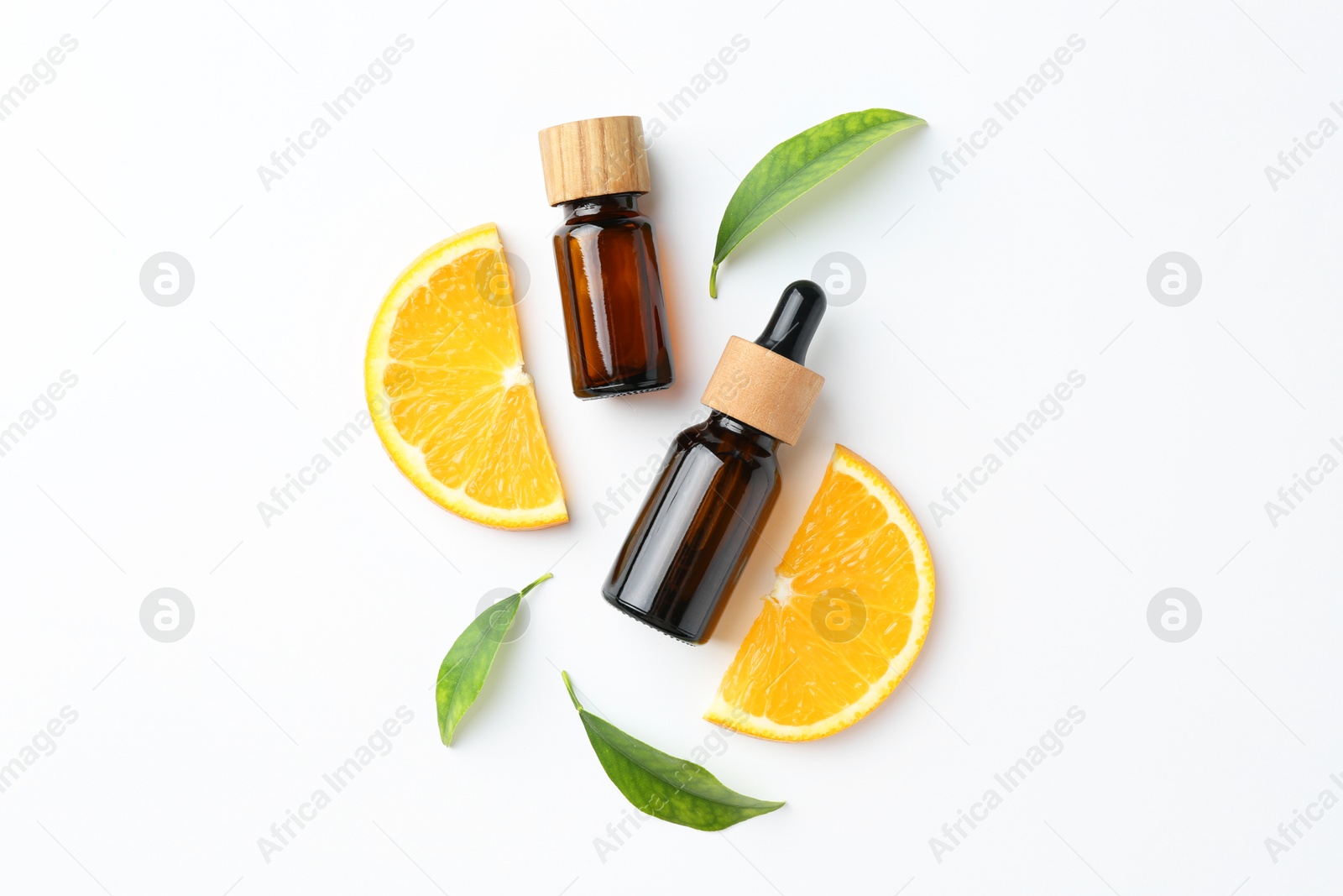 Photo of Bottles of essential oils, orange and green leaves on white background, flat lay