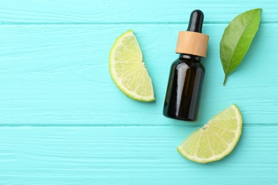 Bottle of essential oil, lime and green leaf on turquoise wooden table, flat lay. Space for text