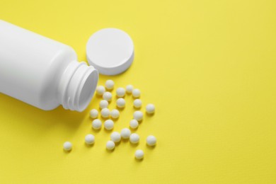 Homeopathic remedy and bottle on yellow background. Space for text