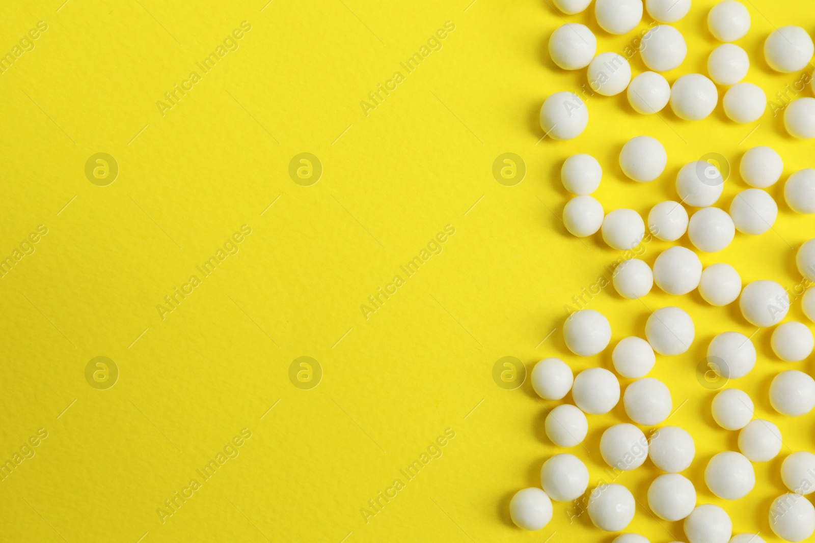 Photo of Homeopathic remedy on yellow background, flat lay. Space for text