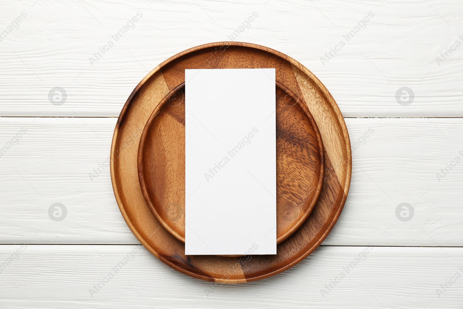 Photo of Empty menu and plates on white wooden table, top view. Mockup for design