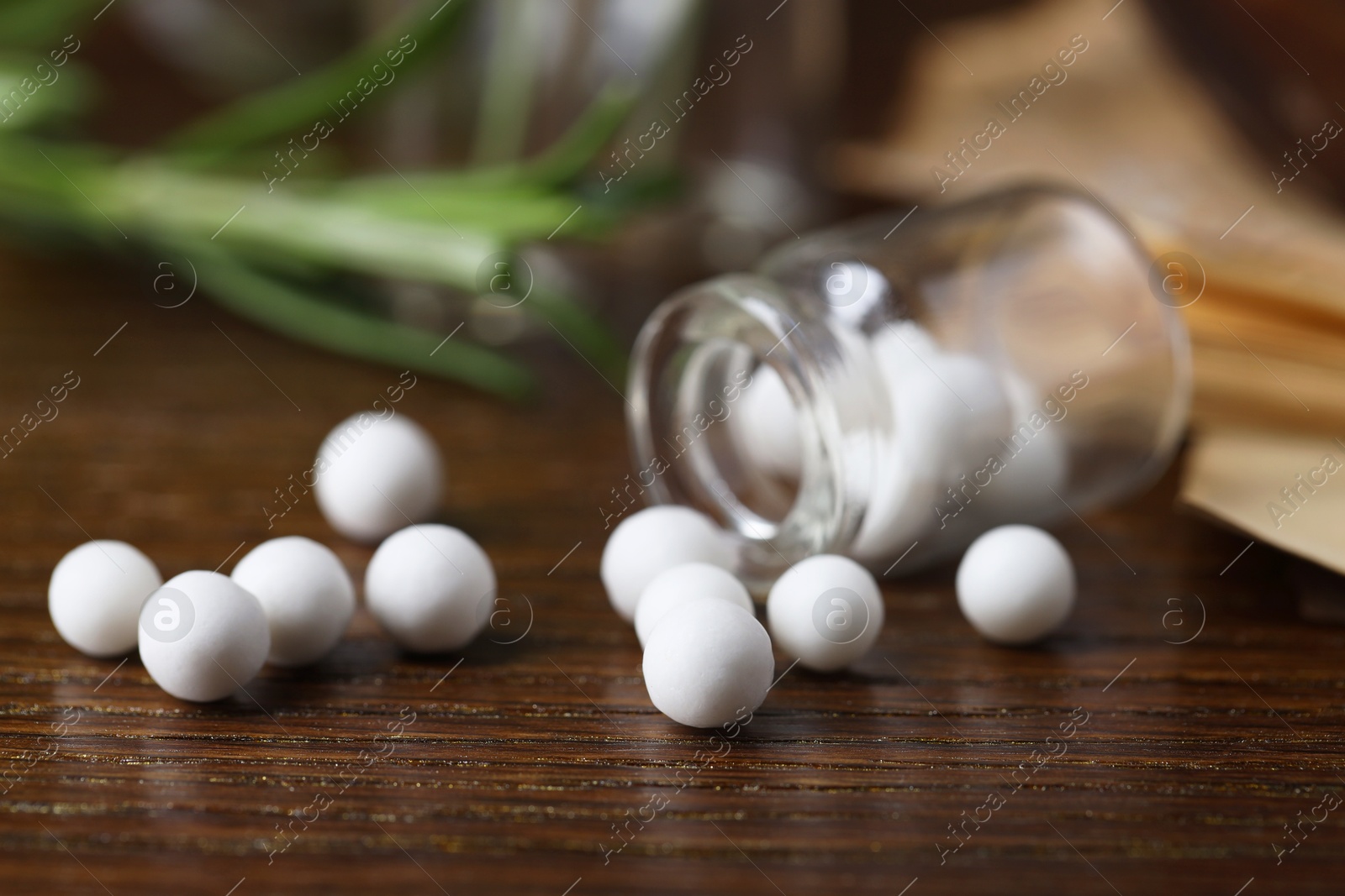 Photo of Homeopathy. Glass bottle with pills on wooden table, closeup