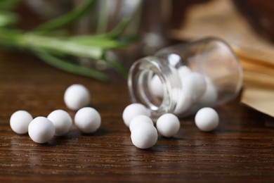 Homeopathy. Glass bottle with pills on wooden table, closeup