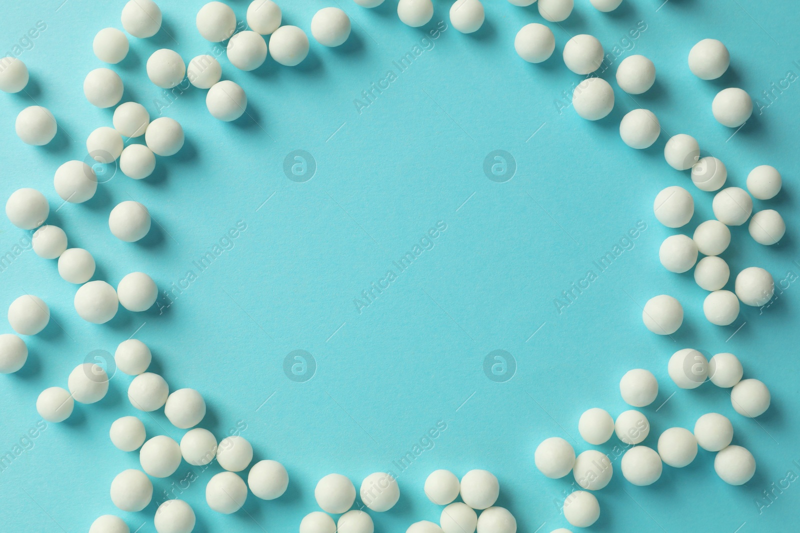 Photo of Homeopathy. Frame made of pills on light blue background, top view. Space for text