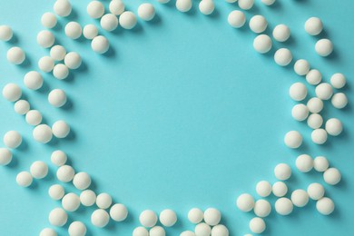 Homeopathy. Frame made of pills on light blue background, top view. Space for text