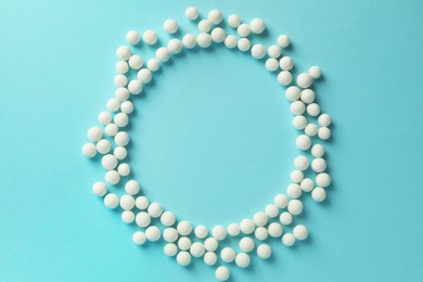 Homeopathy. Frame made of pills on light blue background, top view. Space for text