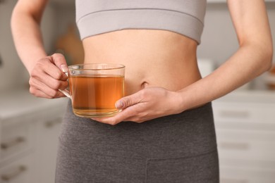 Photo of Weight loss concept. Woman with cup of diet tea indoors, closeup