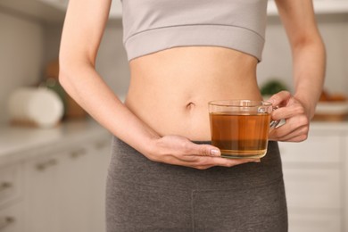 Photo of Weight loss concept. Woman with cup of diet tea indoors, closeup