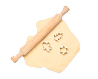 Photo of Raw dough, wooden rolling pin and cookie cutters isolated on white, top view