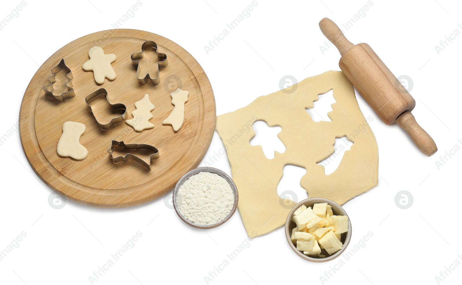 Photo of Raw dough, cookie cutters, board, ingredients and rolling pin isolated on white, above view