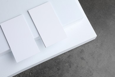 Photo of Blank business cards on grey textured table, flat lay. Mockup for design