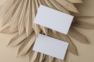 Blank business cards on beige background, flat lay. Mockup for design