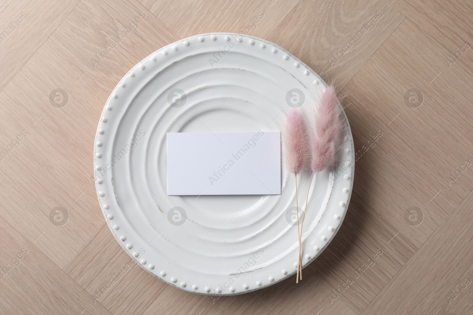 Photo of Blank business cards and dried plants on wooden table, top view. Mockup for design