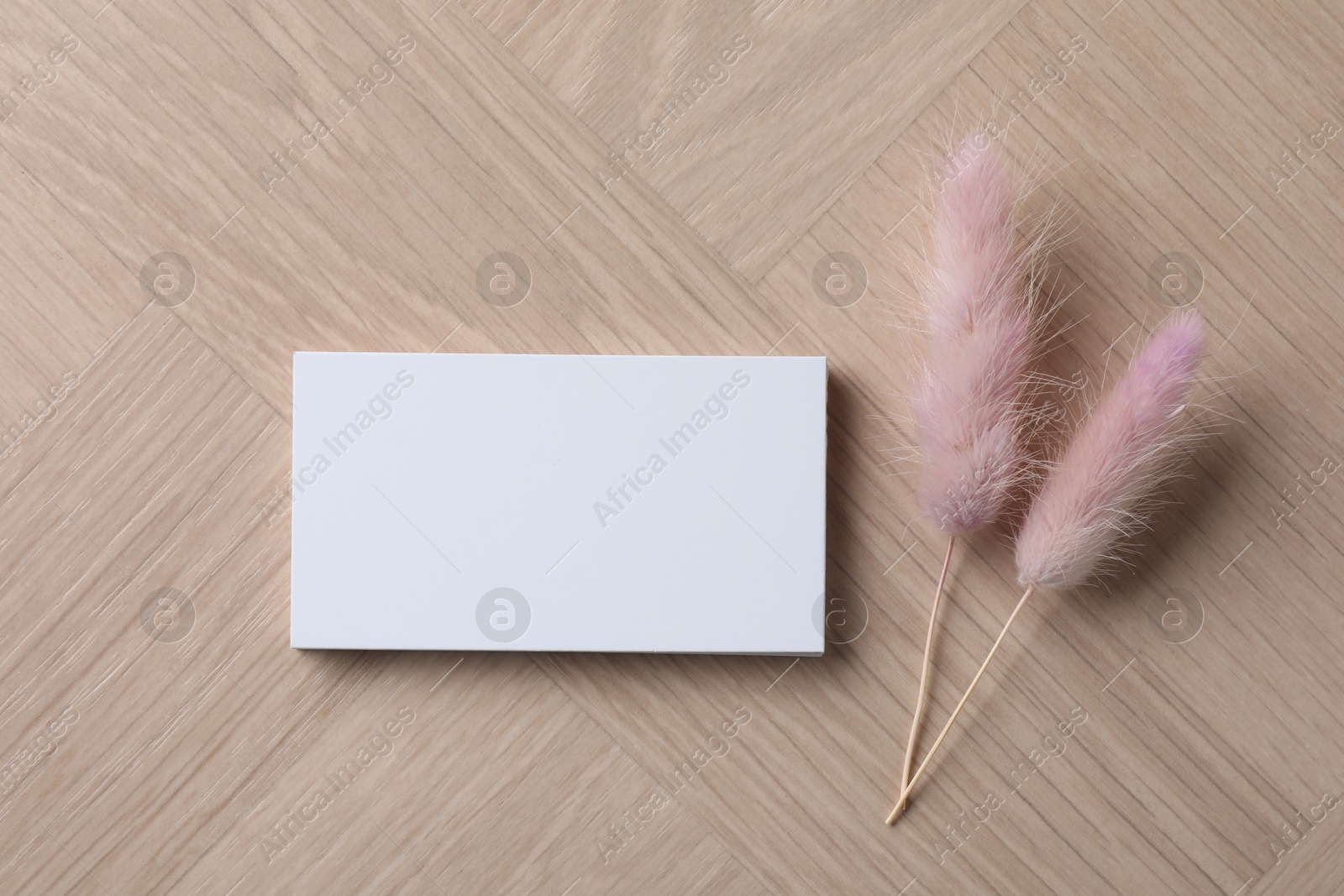 Photo of Blank business cards and dried plants on wooden table, flat lay. Mockup for design