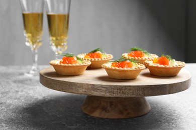 Photo of Delicious canapes with salmon and red caviar on gray table, closeup