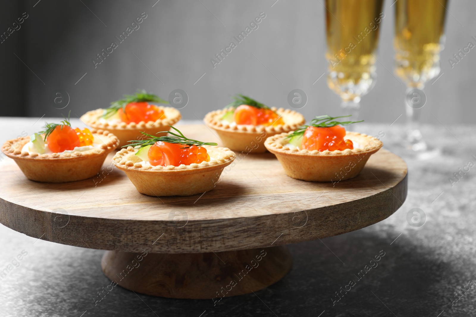 Photo of Delicious canapes with salmon and red caviar on gray table, closeup