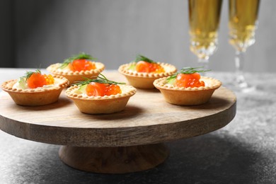 Photo of Delicious canapes with salmon and red caviar on gray table, closeup