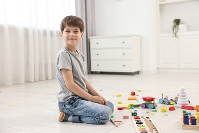 Photo of Cute little boy playing on floor indoors