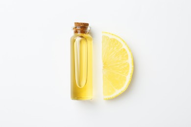 Photo of Bottle of essential oil and lemon on white background, top view