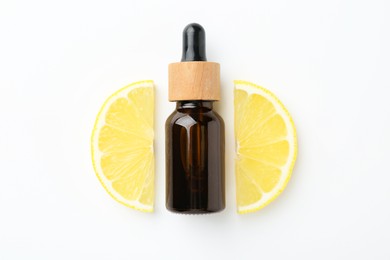 Photo of Bottle of essential oil and lemon on white background, top view