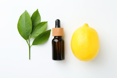 Photo of Bottle of essential oil, lemon and green leaves on white background, flat lay