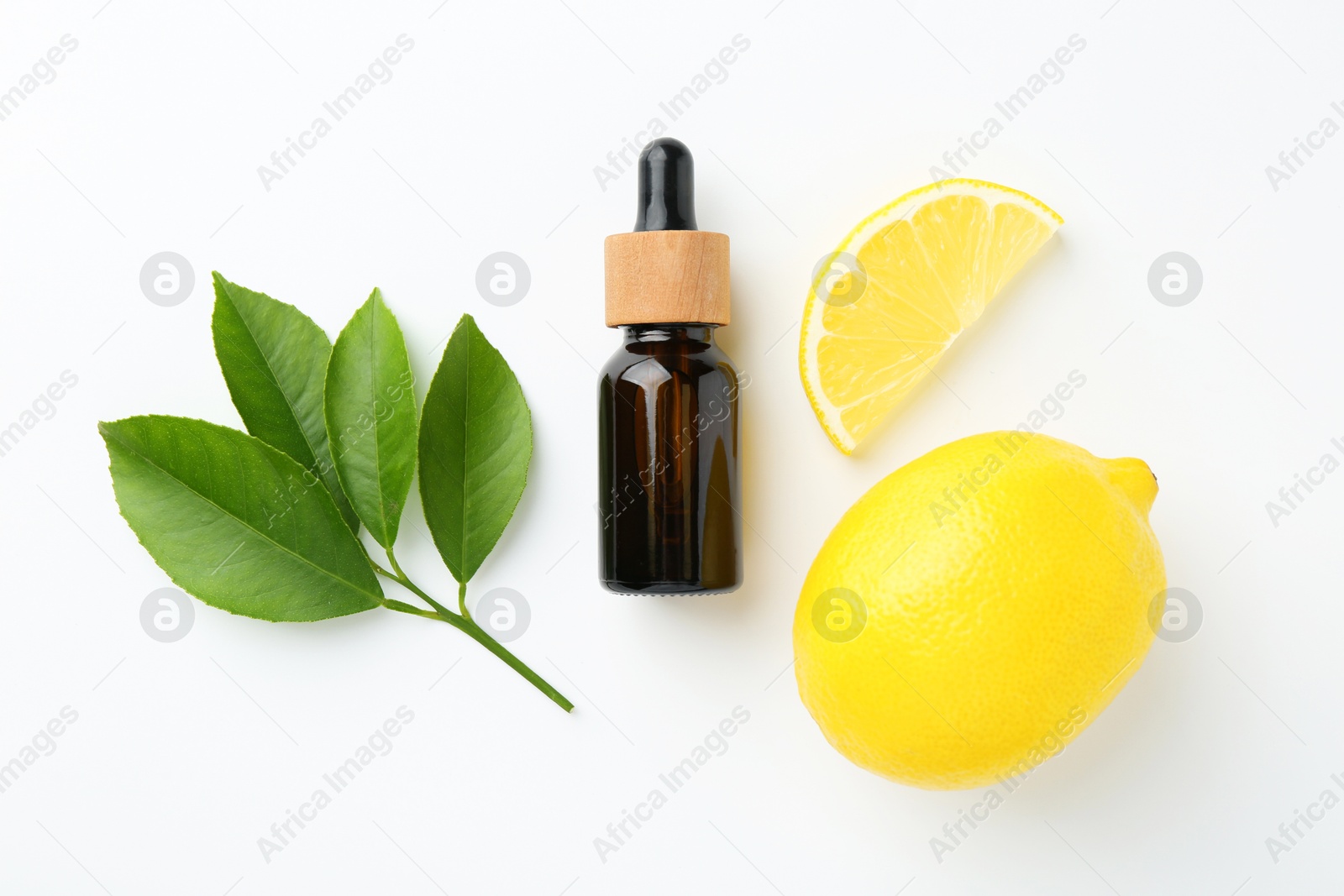 Photo of Bottle of essential oil, lemon and green leaves on white background, flat lay