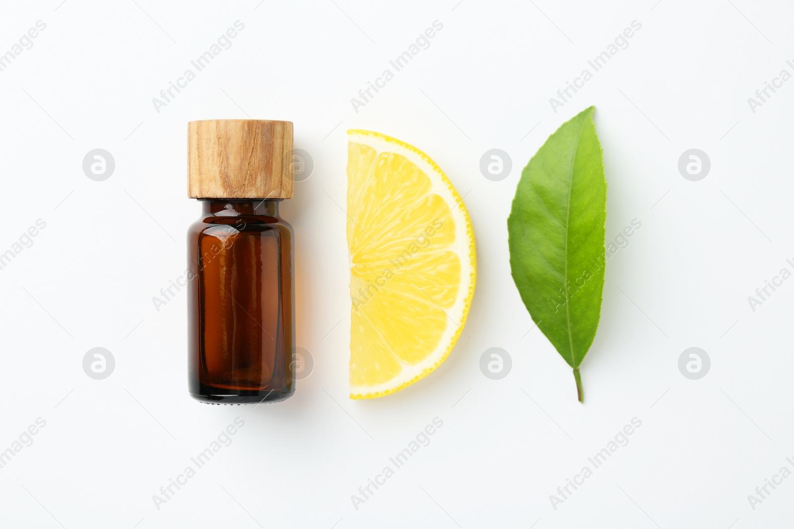 Photo of Bottle of essential oil, lemon and green leaf on white background, flat lay