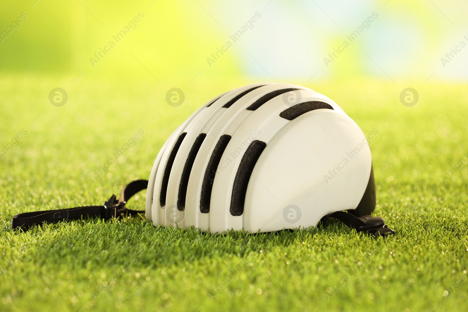 Photo of One white protective helmet on green grass